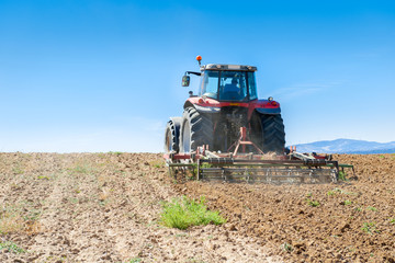 agricultural tractor in the foreground with blue sky background.