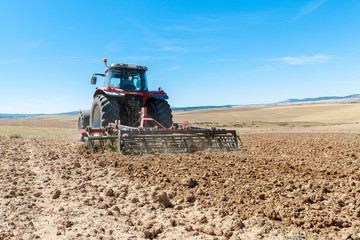Obraz premium agricultural tractor in the foreground with blue sky background.