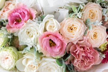 Close-up floral composition with roses and mix flowers on a light background.