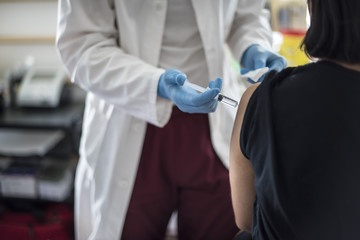 medico fa una vaccinazione sul braccio a una giovane ragazza