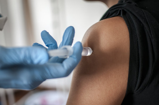 medico fa una vaccinazione sul braccio a una giovane ragazza