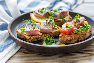 Snack of bread, soft cheese and pickled herring.