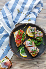 Toasted bread with herring, caviar and greens.