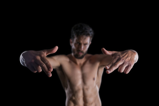 Young sexy bearded man posing pretending shooting with finger guns