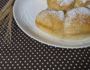 Homemade pastries on a white plate and spikelets of wheat