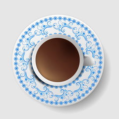 A cup of coffee with a decorative saucer