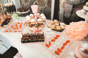 Delicious and tasty dessert table with cupcakes shots at reception closeup