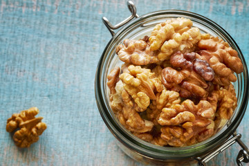 Walnuts in a jar on a rustic wooden background, shallow depth of field.