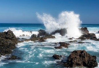 Ocean waves crashing against rocks at Hawaii beach - Powered by Adobe