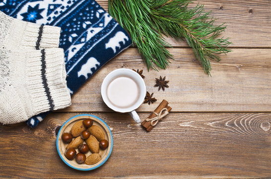 Christmas, winter decor and a mug of cocoa with nuts on a wooden background, holiday concept.