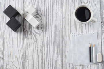 Black and white office concept. Notepad, pencils and coffee on wooden table. Top view, flat lay. Concept of creative work, design.