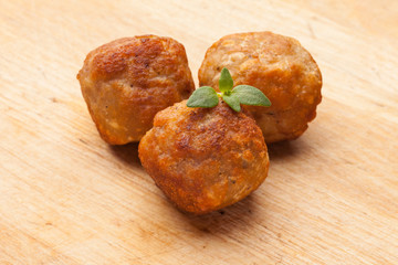 Three meatballs with thyme leave , on rustic wood background
