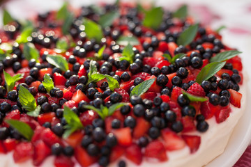 Strawberry and blueberry cake with mint leaves.