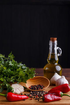 Herbs and spices, olive oil, garlic on wooden table. Kitchen background, cooking concept, suitable for package. Vertical image