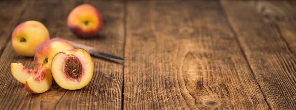 Fresh Peaches on wooden background; selective focus