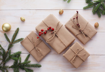 Christmas gift boxes and fir tree branch on wooden table, flat lay