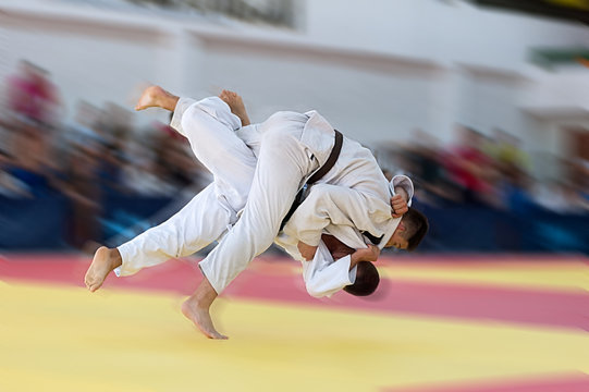 Unrecognizable judoka throwing his opponent with full force