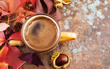 Cup of coffee in and red autumn leaves