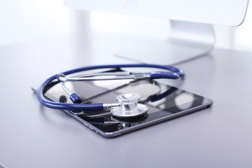 Medical equipment: blue stethoscope and tablet on white background