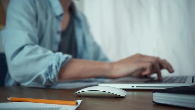 Male hands typing message on laptop