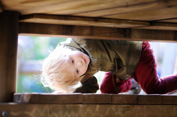 Happy little boy having fun on outdoor playground