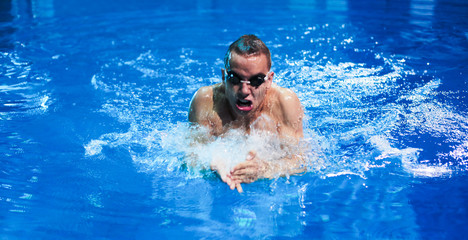 Male swimmer at the swimming pool. Underwater photo