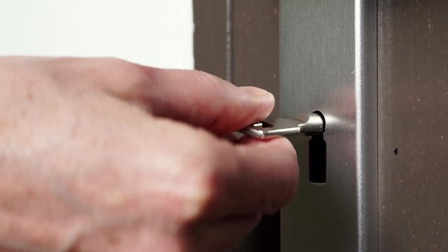 The key is inserted into keyhole of old wooden door and open or close. Home safety and security. 4K ProRes HQ codec