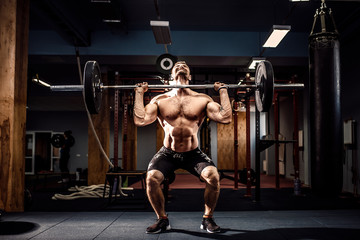Muscular fitness man doing deadlift a barbell over his head in modern fitness center. Functional...