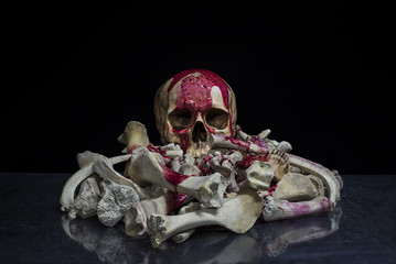 The human skull and pile of bloody bones on dark background /, Still life style, art.