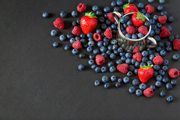 Background of raspberries, strawberry and blueberries. Berry on black background with copy space. Summer and healthy food concept, Top view or flat lay.