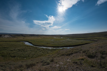Meandering Trout Creek with oxbow lakes  cutting through some plains in Yellowstone National Park with a Bison herd grazing.