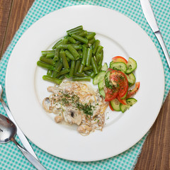 lunch: chicken with mushrooms, green beans and tomato and cucumber salad, top view