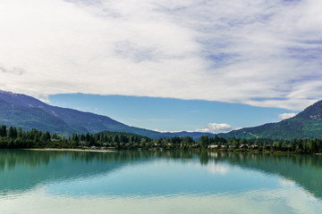 Ttrees reflected in a lake during morning time in Vancouver island Canada.