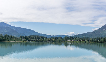 Ttrees reflected in a lake during morning time in Vancouver island Canada.