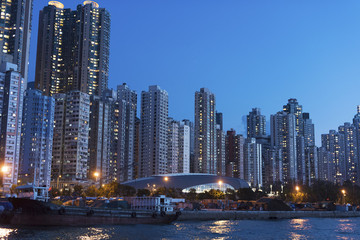 Fototapeta na wymiar High rise residential buildings and harbor of Hong Kong city at dusk