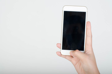 Woman hand holding smartphone with blank screen isolated on white background.