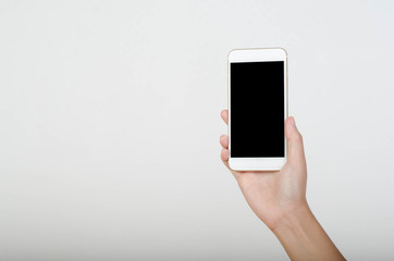 Woman hand holding smartphone with blank screen isolated on white background.