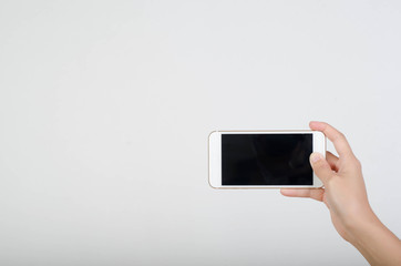 Woman hand holding smartphone with blank screen isolated on white background.