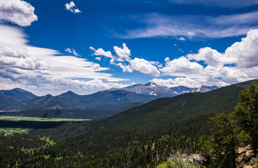 Fototapeta na wymiar Mountain ridge of the Rocky Mountains against the background of a cloudy blue sky. Rocky Mountain National Park