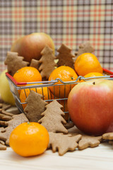 Apples, mandarins, christmas tree cookies in the shopping cart