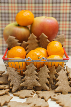 Apples, mandarins, christmas tree cookies in the shopping cart