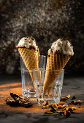 Creamy ice cream with chocolate crumbs in a waffle cone stands in a glass