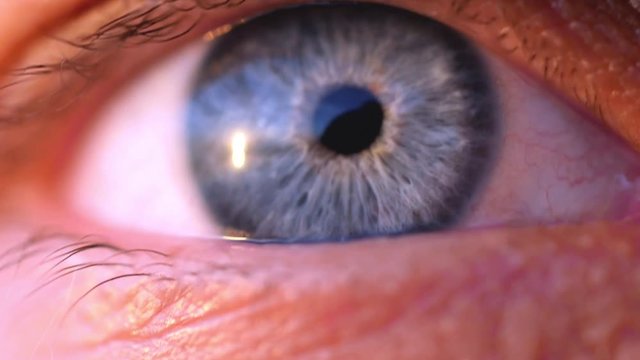Extreme macro shot of opening of a blue eye of young man in slow motion. 1920x1080