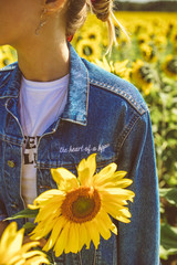 Beautiful stylish hippie girl on the sunflower field
