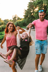 Young family portrait, mother, father and daughter having fun together and hug each other