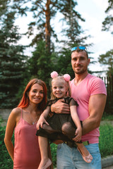 Young family portrait, mother, father and daughter having fun together and hug each other