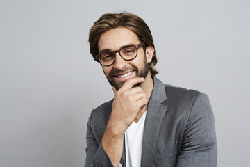 Thoughtful guy in grey suit jacket and glasses