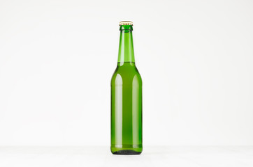 Green longneck beer bottle 500ml, mock up. Template for advertising, design, branding identity on white wood table.