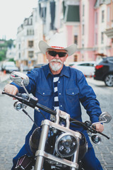 Fototapeta na wymiar A man on a motorcycle, wearing a cowboy hat.
