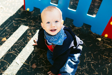 Portrait of a cute child boy with blue eyes, who is starring at the camera and smile.Outdoors healthy child activity, active lifestyle and having fun on family summer vacation with son at the playgrou